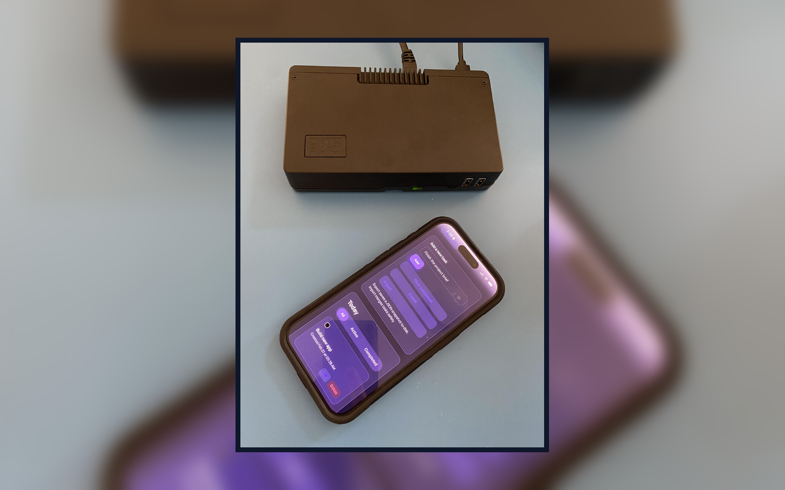 Landscape card image showing the OurBox device and a smartphone screen inside a framed photo against a blurred background.