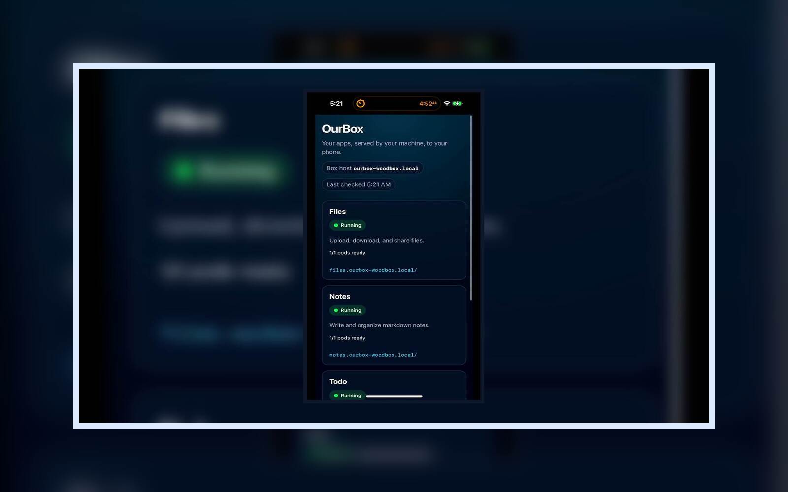 Landscape card poster showing the OurBox dashboard on a phone centered over a blurred dark background.